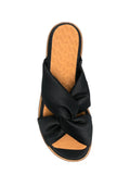 Chie Mihara Wamuza designer comfort sandals, premium leather insole and soft black satin twisted cross-strap upper, slow fashion shoes sustainable craftsmanship footwear Spain

